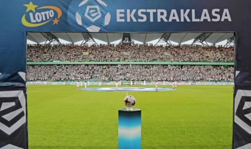 Piłka Ekstraklasy na tle boiska piłkarskiego