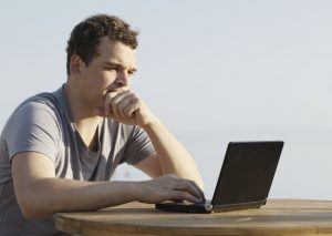 młody mężczyzna pracujący na laptopie