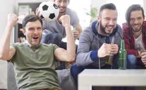 grupa młodych mężczyzn oglądających mecz