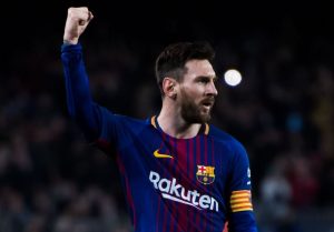 Lionel Messi z uniesioną dłonią na stadionie piłkarskim