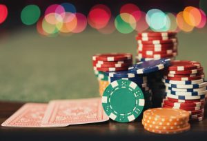 stos żetonów i karty do gry na pokerowym stole