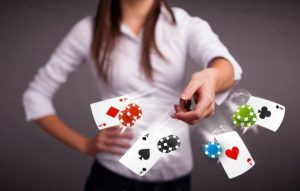 karty do gry i żetony pokerowe rzucane w stronę obiektywu przez młodą dziewczynę