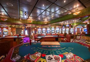 wnętrze kasyna ze stołami pokerowymi i automatami do gier