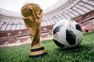 piłka do futbolu oraz puchar MŚ na murawie boiska