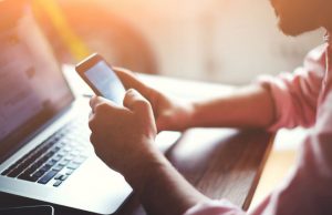 mężczyzna typujący na telefonie komórkowym