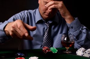 mężczyzna rzucający karty na stół do pokera