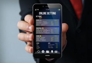 dłoń trzymająca telefon z aplikacją do typowania