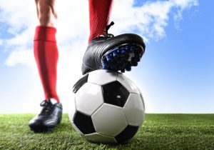 stopy piłkarza i piłka do futbolu na murawie